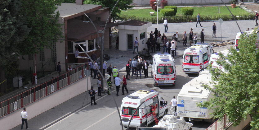 Straßenszene mit Menschen und Krankenwagen