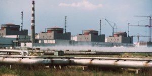 Blick auf das ukrainische Atomkraftwerk Saporoschje. Im Vordergrund verlaufen angerostete Rohre.