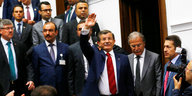 Davutoğlu winkt, umringt von vielen Männern