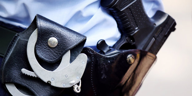 Ein Polizist trägt Handschellen und eine Pistole am Gürtel