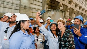 Inmitten von Mitarbeitern und Mitarbeiterinnen des Wasserkraftwerks Belo Monte steht die brasiliansiche Präsidentin Rousseff und lässt ein Selfie von sich und einer Mitarbeiterin machen.