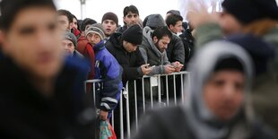 Viele Menschen stehen Schlange. Es scheint kalt zu sein, da sie warme Kleidung anhaben.