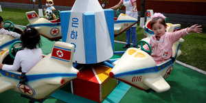 Fröhliche Kinder auf einem Karussell mit Fluggeräten