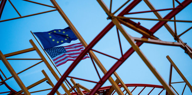 An einem Achterbahngerüst angebrachte Flaggen der EU und der USA