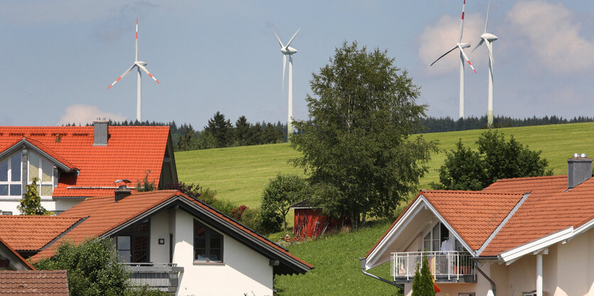 Wohnhäuser, im Hintergrund Windräder