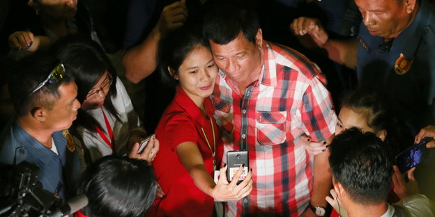 Der philippinische Präsidentschaftswahlsieger Rodrigo Duterte macht ein Selfie mit einer Unterstützerin