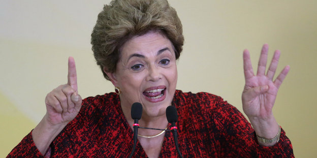 Dilma Rousseff gestikulierend an zwei Mikrofonen