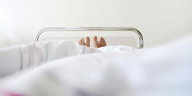 Füße schauen aus einem Krankenhausbett hervor