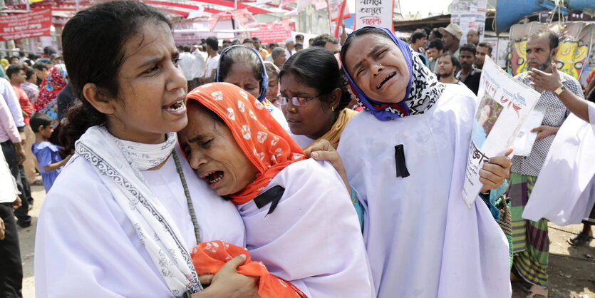 Angehörige weinen um die Opfer des eingestürzten Rana Plaza