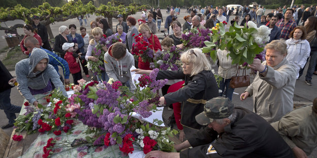 Dutzende Menschen legen Blumen ab