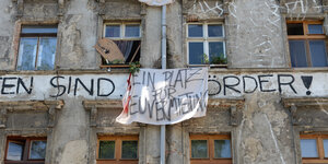 An einer grauen Hauswand hängt ein Transparent mit der Aufschrift „Kein Platz für Neuvermietung“