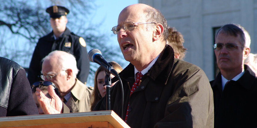 Ein Mann, Michael Ratner, an einem Pult