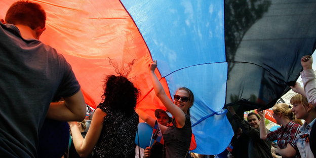 Menschen unter einer Flagge in Rot-Blau-Schwarz