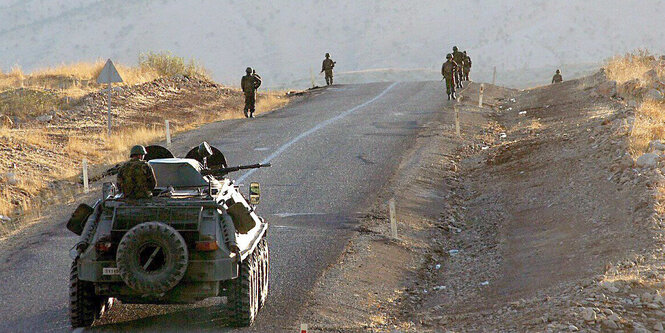 Panzerwagen und Soldaten auf einer Straße