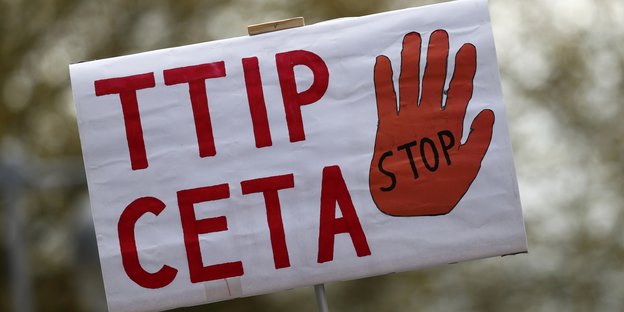 Auf einem Plakat steht TTIP und Ceta. Daneben ist eine rote Hand abgebildet.