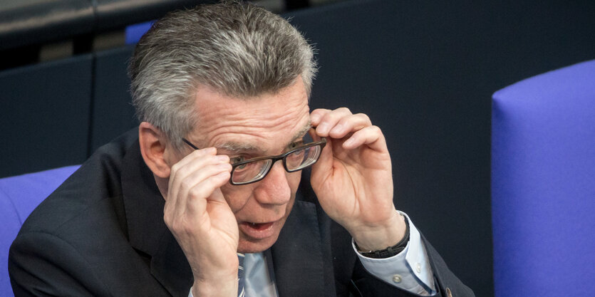 Thomas de Maiziére fasst sich an die Brille