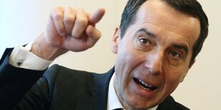 Ein Mann zeigt mit seinem Finger nach vorne. Es ist Christian Kern