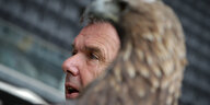 Das Gesicht eines Mannes im Profil hinter einer Adlerstatue