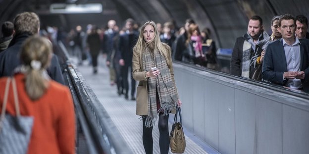 Rush Hour in der Londoner Ubahn, Menschen halten ihre Smartphones in der Hand