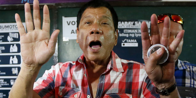 Rodrigo Duterte hält seine Handflächen in die Höhe