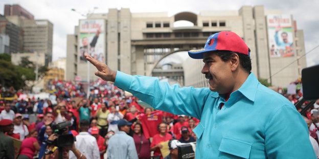Ein Mann winkt einer Menschenmenge zu, es ist Präsident Nicolás Maduro