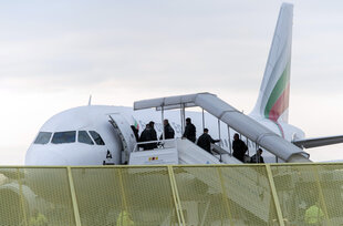 Menschen steigen in ein Flugzeug ein