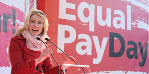 Manuela Schwesig spricht vor einem Plakat des „Equal Pay Day“