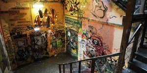 ein Treppoenhaus mit mit Graffitis und Plakaten