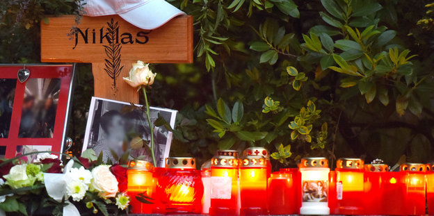 Ein Holzkreuz mit der Aufschrift "Niklas" und brennende Kerzen stehen am Gedenkort