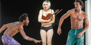 zwei Männer mit freien Oberkörpern und eine Frau in Unterwäsche die eine Geige vor der Brust hält