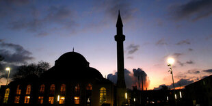 Ein Minarett in Duisburg-Marxloh vor der untergehenden Sonne.