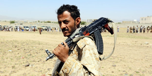 Ein Sympathisant der Huthi-Miliz trägt ein Maschinengewehr auf der Schulter