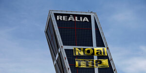Greenpeace-Aktivisten befestigen ein gelbes Banner an der Fassade eines der Kio Towers in Madrid