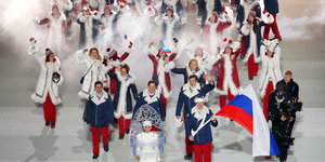 Frauen und Männer in Pelzmänteln, einer trägt eine russische Fahne