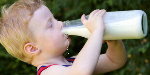 Ein Kind trinkt Milch aus einer Flasche