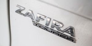 Das Logo von Opel Zafira auf einer grauen Autotür