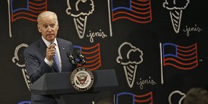 Joe Biden steht an einem Pult mit Mikrofonen