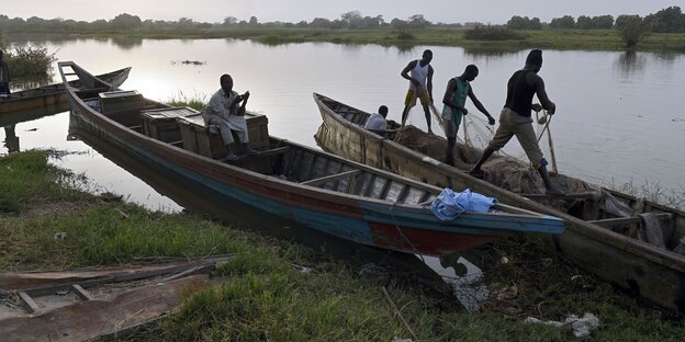 In Booten stehende Fischer werfen ihre Netze am Rande des Tschadsee aus