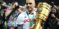 Pep Guardiola mit Pokal, um ihn herum Fotografen