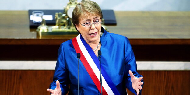 Die chilenische Präsidentin in blauem Anzug und Schärpe in den chilenischen Nationalfarben