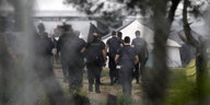 Polizisten laufen in das Flüchtlingscamp Idomeni