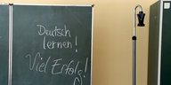 auf einer Schultafel steht mit Kreide geschrieben: „Deutsch lernen! Viel Erfolg“