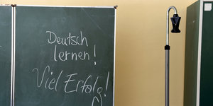 auf einer Schultafel steht mit Kreide geschrieben: „Deutsch lernen! Viel Erfolg“