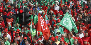 Menschen mit grünen und roten Anziehsachen auf einer Demo