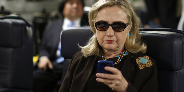 Hillary Clinton mit Sonnenbrille und Handy