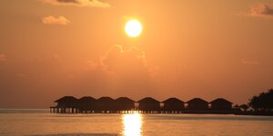 Stelzenhäuser auf den Malediven im Sonnenuntergang