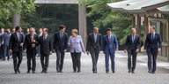 Die Staatspräsidenten des G7 Gipfels gehen nebeneinander einen Weg entlang