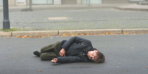 Ein blutender Junge liegt auf der Straße