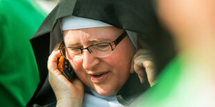 Eine Nonne telefoniert mit einem Handy.