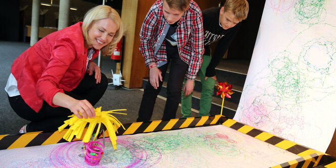 Familienministerin Manuela Schwesig mit einem Mal-Roboter.